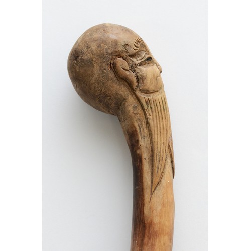 198 - An Oriental walking stick of tapering form, the handle carved with the head of a Chinese Immortal, 9... 