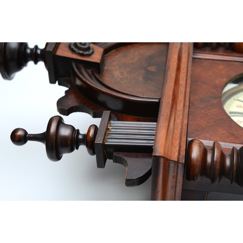 266 - A late 19th century mahogany cased Vienna style wall clock, with arched pediment and turned finales ... 