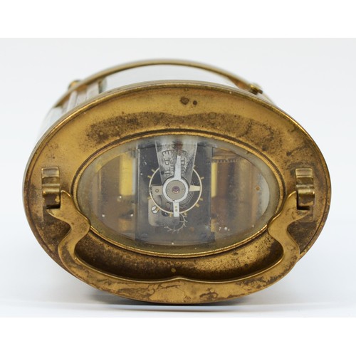 236 - An early 20th century gilt brass carriage clock, of oval form with swing handle on bun feet, having ... 