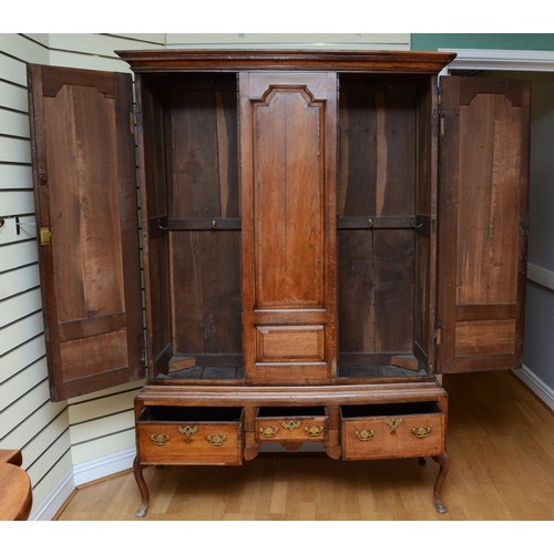 356 - A George III oak livery cupboard, projecting moulded cornice over two panelled doors, the upper pane... 