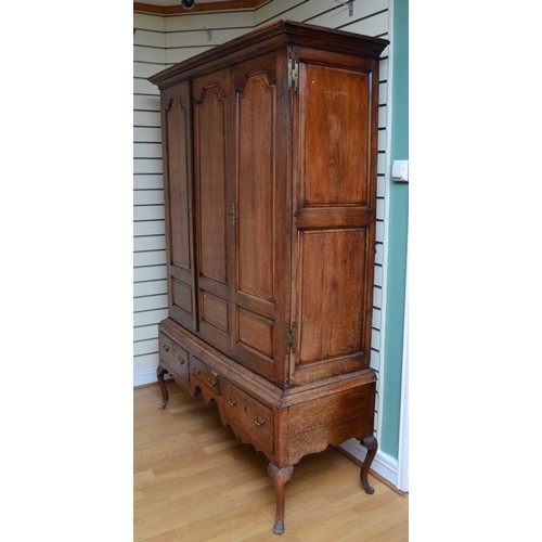 356 - A George III oak livery cupboard, projecting moulded cornice over two panelled doors, the upper pane... 