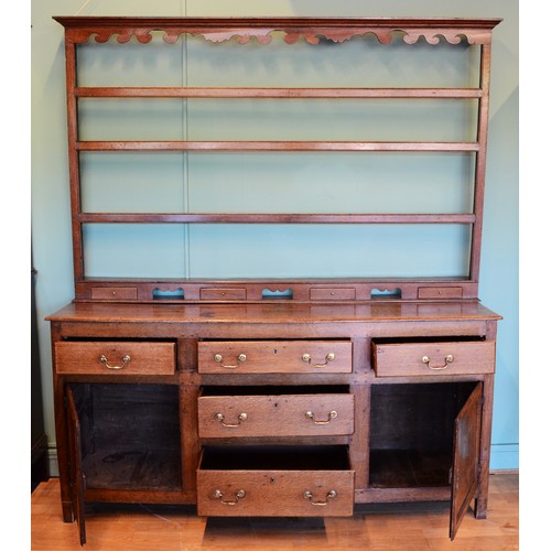 363 - A 19th century Georgian oak dresser, projecting cornice over shaped apron and three-tier plate rack,... 