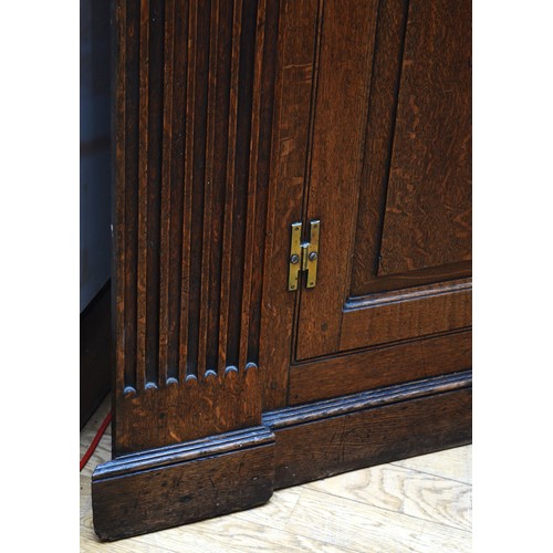 375 - A large George III oak corner cupboard, projecting cornice over two stepped arch doors with fielded ... 