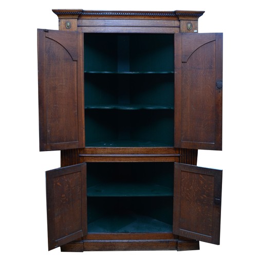 375 - A large George III oak corner cupboard, projecting cornice over two stepped arch doors with fielded ... 