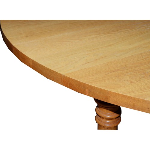 376 - A substantial and impressive modern dining table, light coloured solid oak construction, the rounded... 