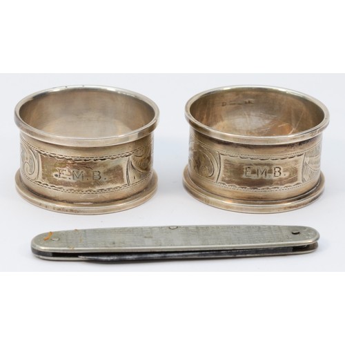 8 - A pair of silver napkin rings, Birmingham 1932, both with E.M.B. initials and a metal Kings and Quee... 