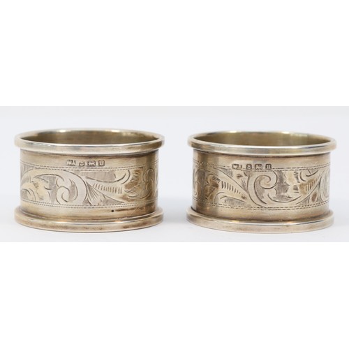 8 - A pair of silver napkin rings, Birmingham 1932, both with E.M.B. initials and a metal Kings and Quee... 