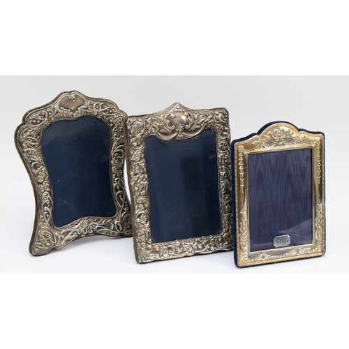 17 - A silver shaped and embossed photograph frame, Sheffield 1990, 19 x 15cm and two other silver photog... 