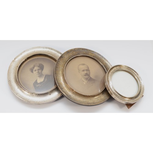 18 - A pair of silver circular photograph frames, Birmingham 1910, 15.5cm and another smaller example (3)... 