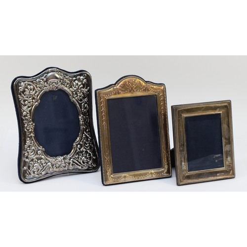 20 - A silver shaped photograph frame, London 1987, 18 x 14cm and two smaller silver photograph frames (3... 