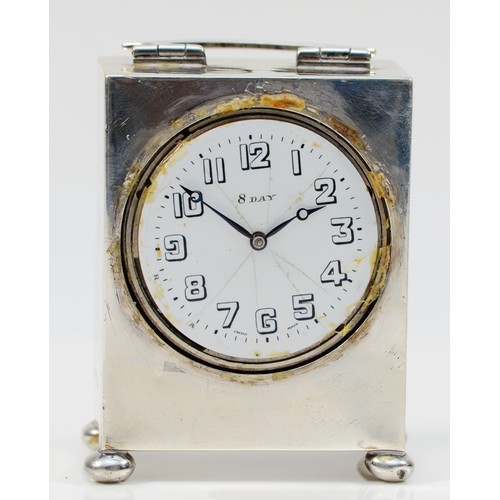 106 - A silver eight day bedside clock, Chester 1920, raised on four ball feet, 6.5 x 5 x 3cm.
Lacking bez... 