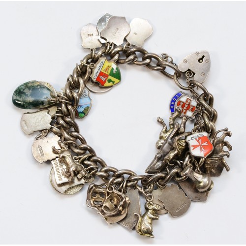 181 - A silver charm bracelet with multiple charms, 87gm