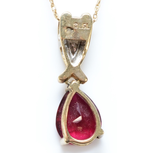 304 - A 9ct gold red stone and brilliant cut diamond pendant, 21mm, chain, 2.1gm