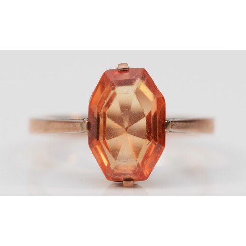 554 - An unmarked 9ct rose gold and orange gemstone ring, M 1/2, 2.9gm