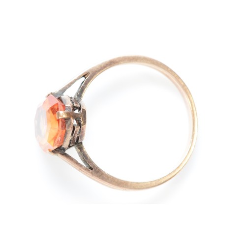 554 - An unmarked 9ct rose gold and orange gemstone ring, M 1/2, 2.9gm