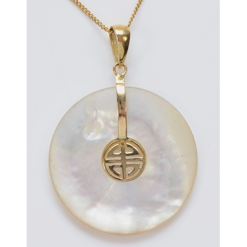 557 - A Chinese 14K gold and mother of pearl disc pendant, diameter 24mm, chain