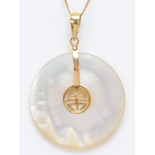 557 - A Chinese 14K gold and mother of pearl disc pendant, diameter 24mm, chain