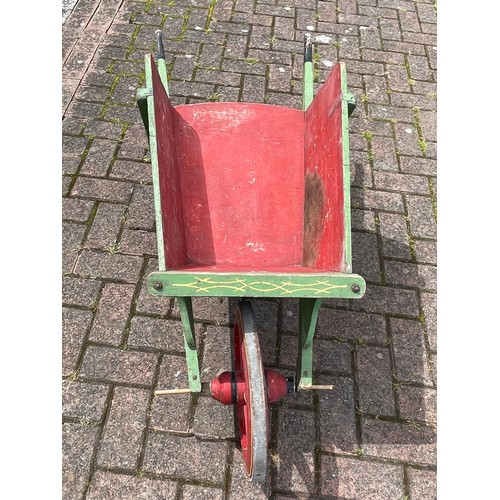 26 - A decorative painted pine wheelbarrow, 125cm long.