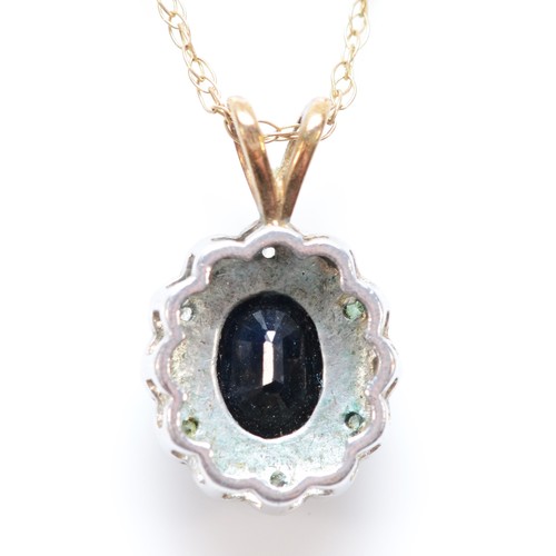 23 - A 9ct gold oval cut sapphire and diamond cluster pendant necklace, 13mm pendant, 2.3g