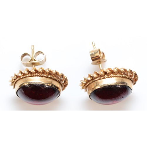 62 - A pair of 9ct gold cabochon garnet stud earrings, bezel set with scroll backs, 3.3g