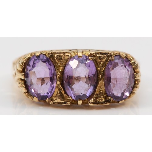 66 - A 9ct gold antique oval cut amethyst three stone ring with a heart patterned gallery, O 1/2, 3.6g