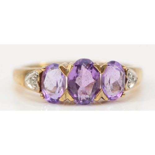 120 - A 9ct gold amethyst three stone ring, N, 3g