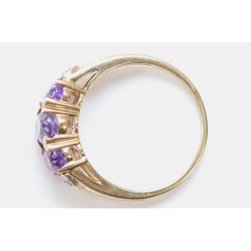 120 - A 9ct gold amethyst three stone ring, N, 3g