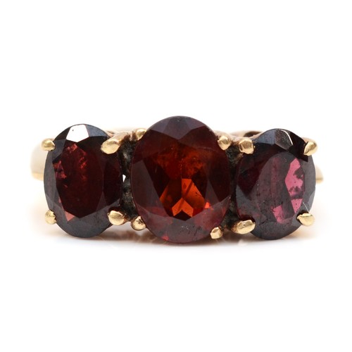 139 - A 9ct gold and three stone garnet ring, largest stone 9 x 7mm, O, 4.8gm