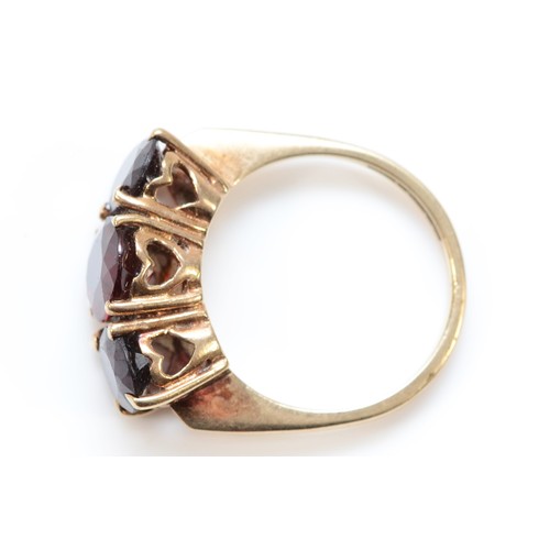 139 - A 9ct gold and three stone garnet ring, largest stone 9 x 7mm, O, 4.8gm