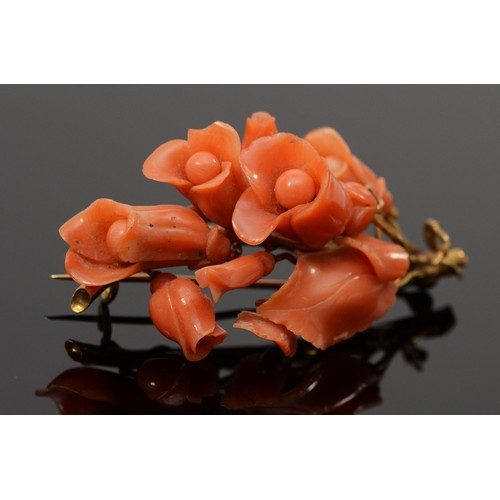 An early 19th century Neapolitan coral and high carat gold brooch, c.1830/40, mounted with carved flowers and leaves, one setting vacant, bearing control marks, 57mm, 5.3gm