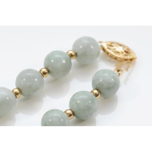 255 - A 7mm jadeite bead necklace with 14K beads between, 46cm