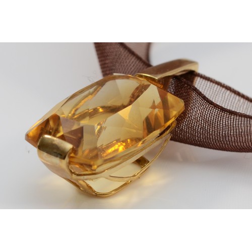 262 - A 9ct gold mounted citrine pendant, of good cut and colour, mounted on a gold mounted fabric ribbon,... 