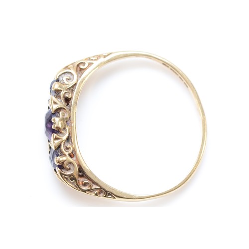 312 - A 9ct gold amethyst three stone ring, carved setting, both end stones with chips, S, 2.6gm