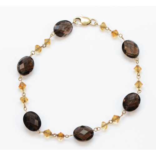 6 - A 9ct gold faceted smokey quartz and citrine bracelet, 17.5cm, 5g