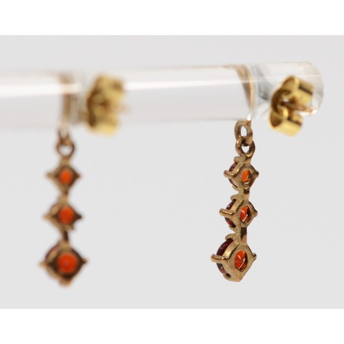 53 - A pair of 9ct gold graduated garnet drop earrings with scroll backs, 20mm drop, 1g