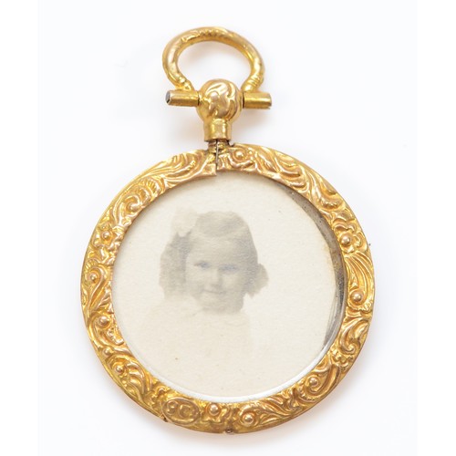 71 - A 9ct gold patterned locket with photographs, 27mm diameter, 3.4g