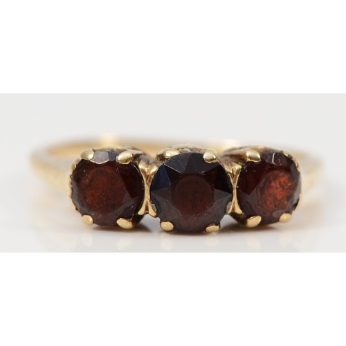 85 - A 9ct gold garnet three stone ring, K, 1.8g