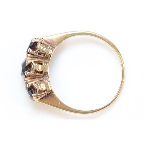 85 - A 9ct gold garnet three stone ring, K, 1.8g