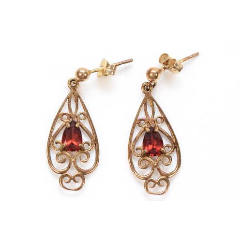 97 - A pair of 9ct rose gold pear cut garnet set ornate drop earrings, 25mm drop, 1.7g