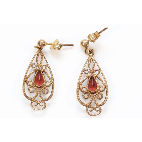 97 - A pair of 9ct rose gold pear cut garnet set ornate drop earrings, 25mm drop, 1.7g