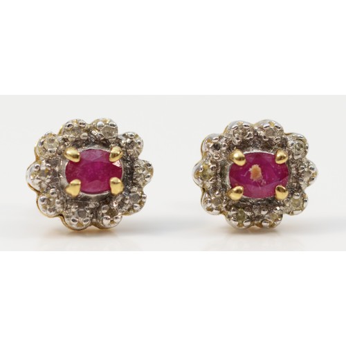 127 - A pair of 9ct gold oval cut ruby and diamond cluster earrings with scroll backs, 1.4g