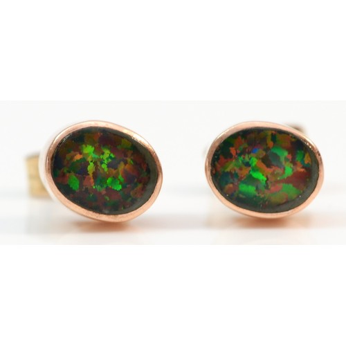 396 - A pair of 9ct rose gold synthetic black opal triplet cabochon stud earrings, 1.7g