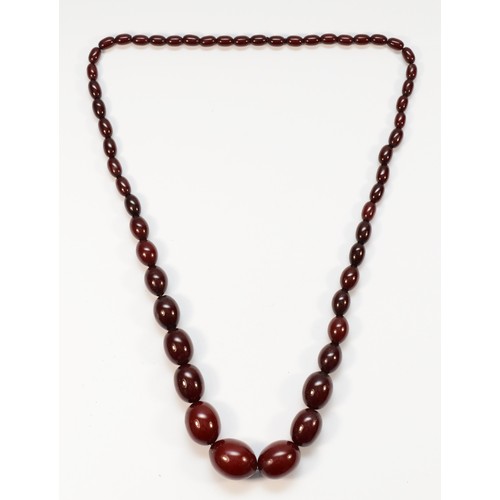 54 - A cherry amber Bakelite graduated bead necklace, the largest 28 x 20mm, 81gm.