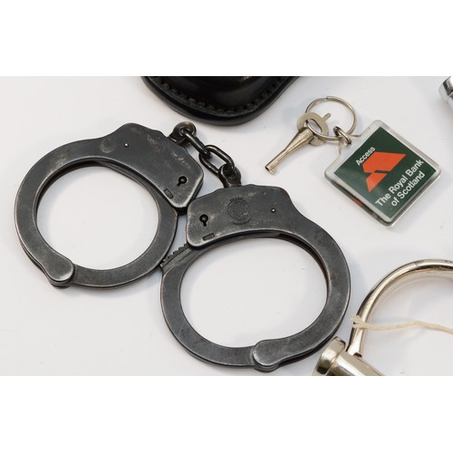 74 - Three pairs of hand cuffs, with keys and a leather case