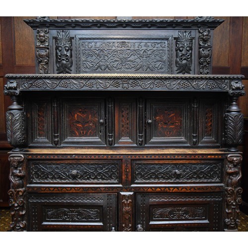 42 - A 17th Century and later carved oak court cupboard, top panel with G.L, 1649, flanked by grotesque m... 