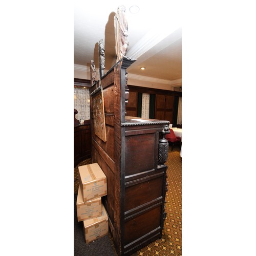 42 - A 17th Century and later carved oak court cupboard, top panel with G.L, 1649, flanked by grotesque m... 