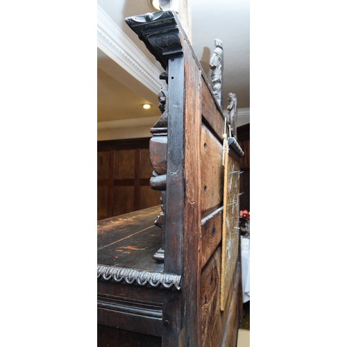 42 - A 17th Century and later carved oak court cupboard, top panel with G.L, 1649, flanked by grotesque m... 