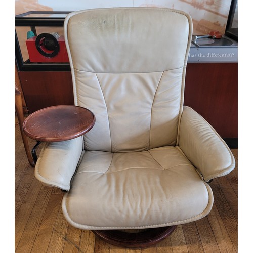 132 - A modern Ekornes tan leather swivel recliner armchair, together with a pair of glass topped occasion... 