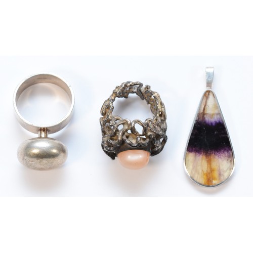 16 - A silver button ring, by LK, London 1968, an unmarked silver abstract pink stone ring and a Blue Joh... 