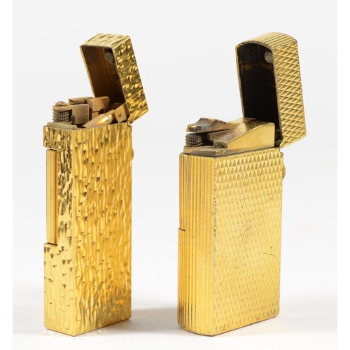 6 - Dunhill, a gold plated textured rollagas lighter, booklet and box and another by the same, serial nu... 